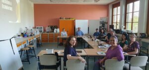 Gruppenfoto der Partner im Kreativlabor: Alle sitzen um einen U-förmigen Tisch
